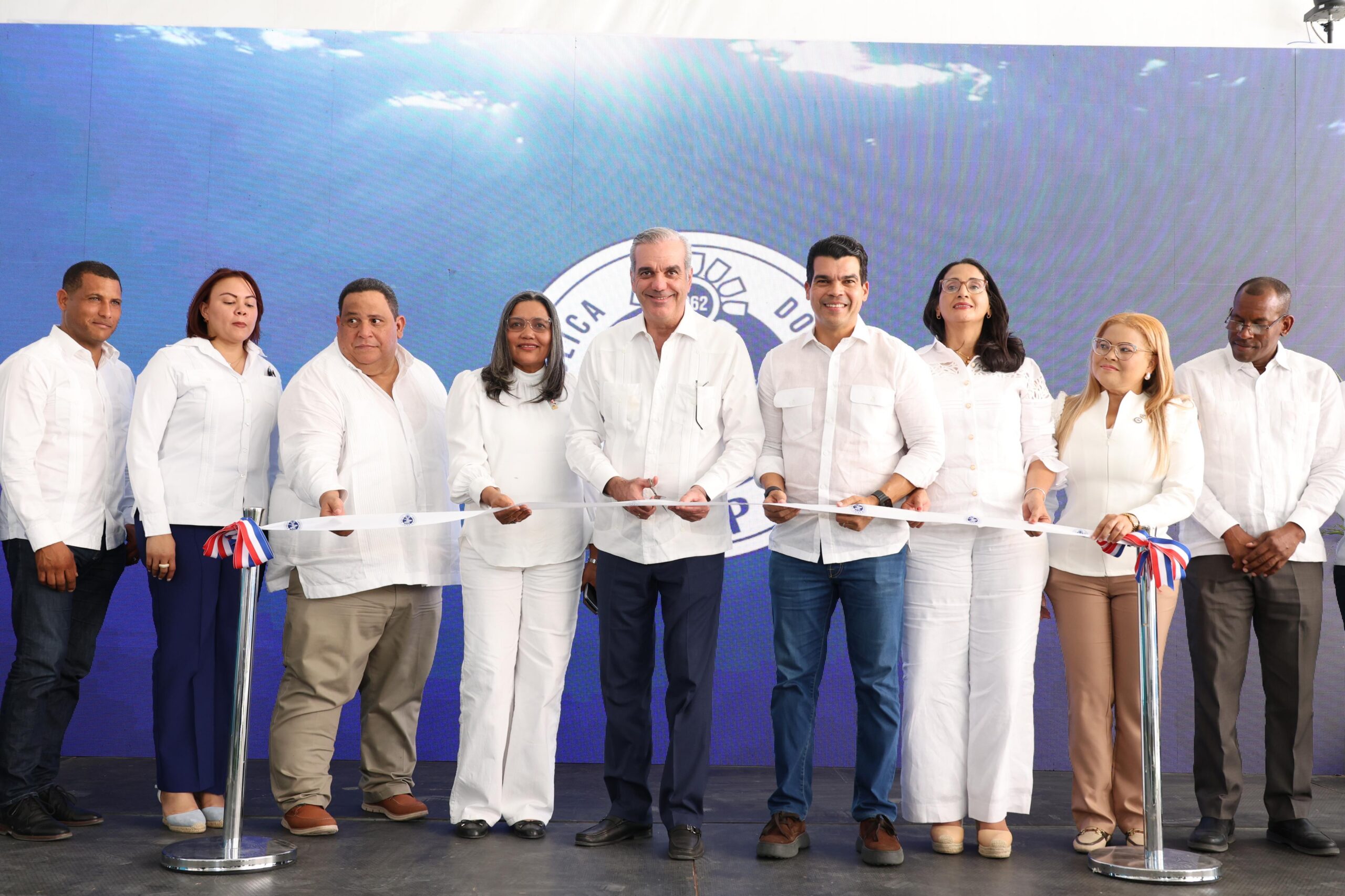Presidente Luis Abinader y director del INAPA, Wellington Arnaud, realizan el corte de cienta para dejar inaugurada las obras en Azua. Les acompañan autoridades de la zona.
