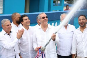 El presidente Luis Abinader y Wellington Arnaud, director del INAPA, abren el grifo para dejar inaugurado el acueducto de Villa Altagracia